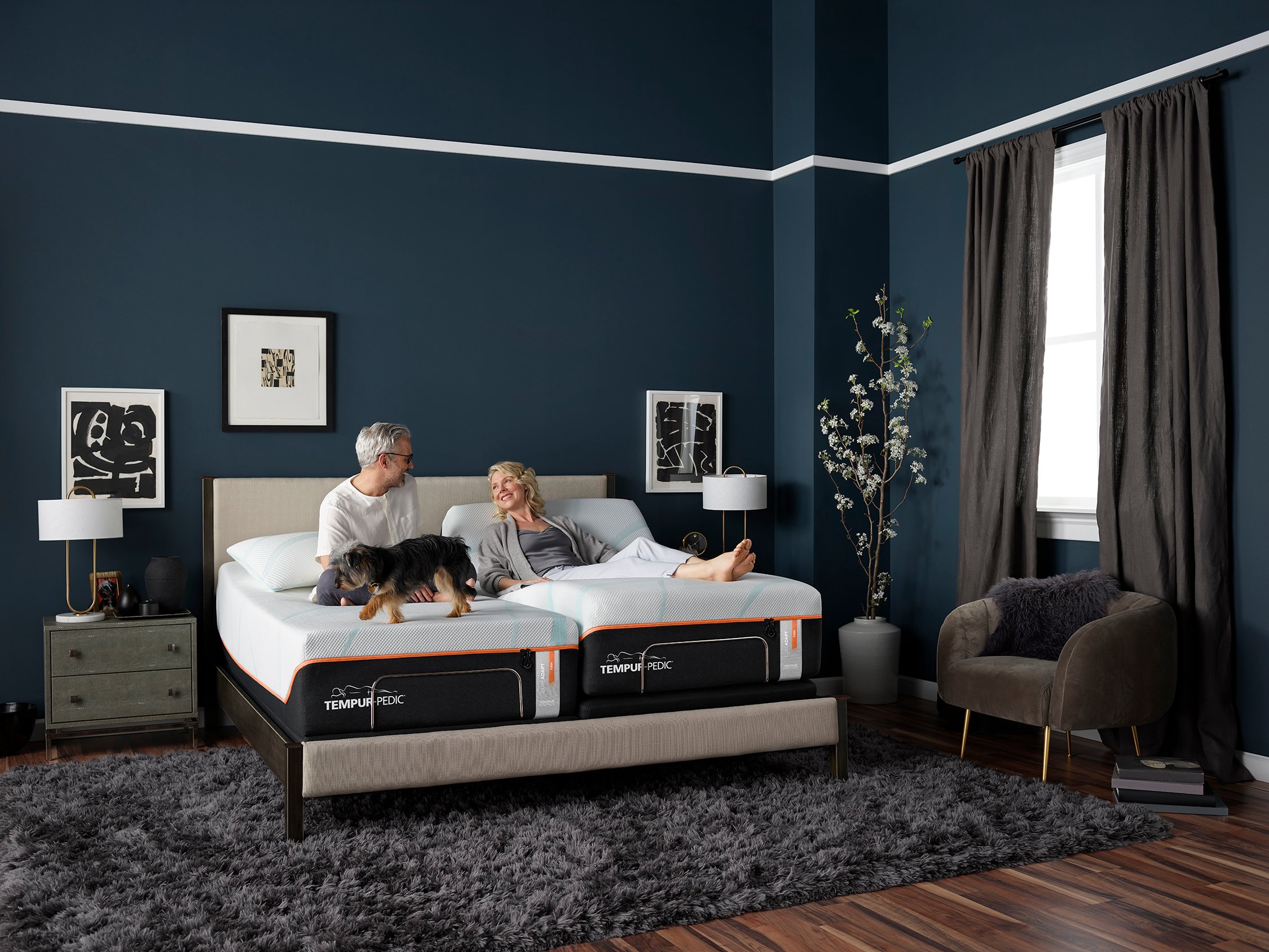 An elderly couple relaxes on a Tempur-Pedic bed.