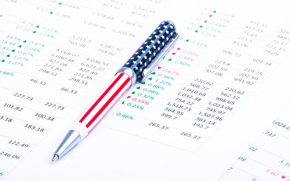 An American flag-themed pen lying atop a printout of financial data. 