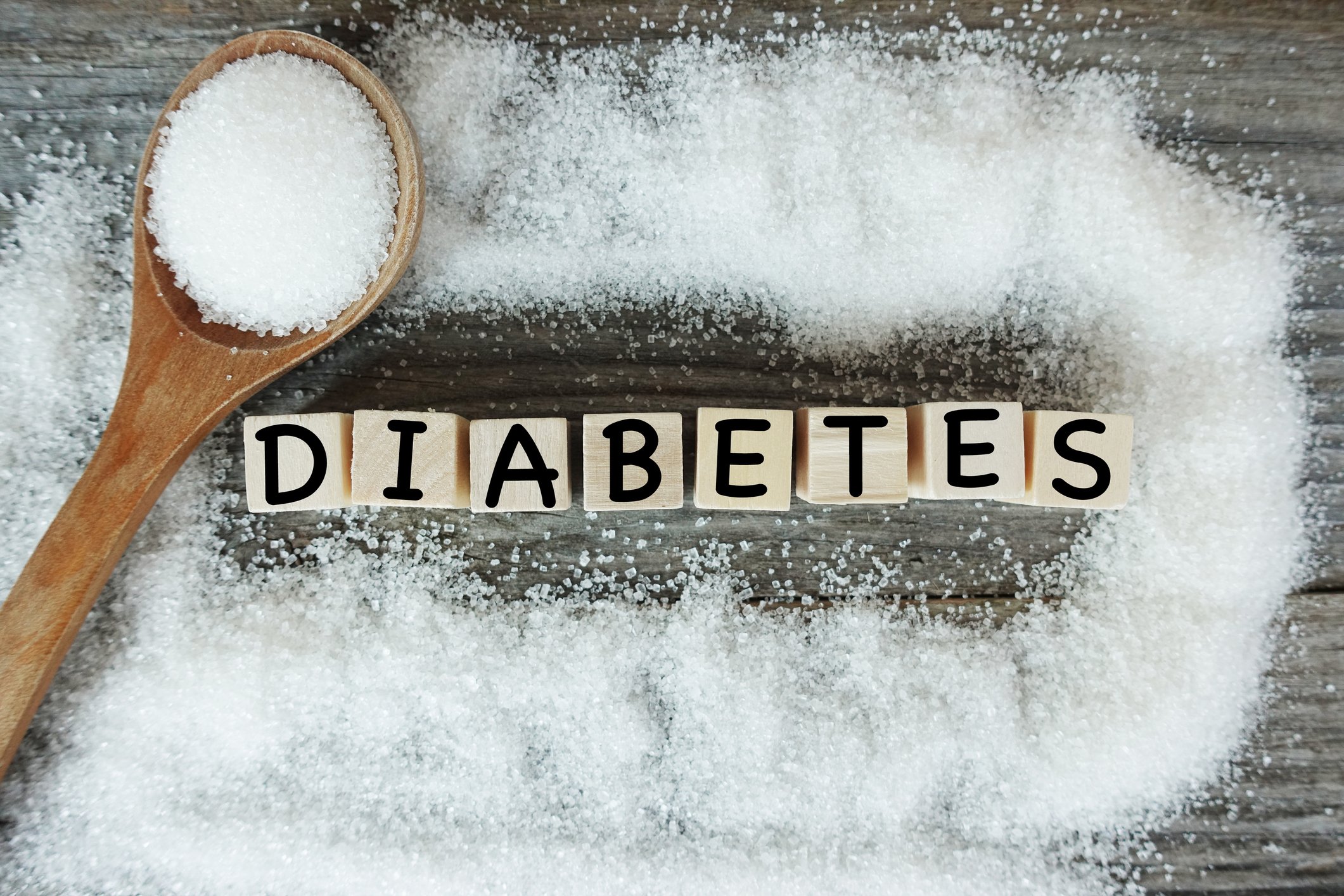 Diabetes word on wooden letters with crystalized white sugar as frame. 