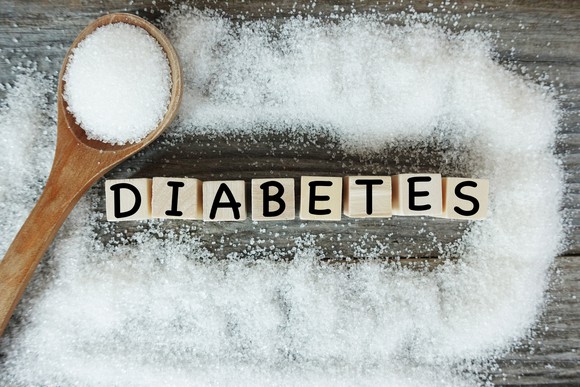 Diabetes word on wooden letters with crystalized white sugar as frame. 