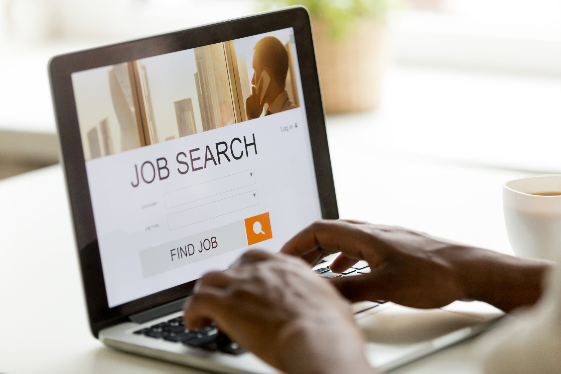 A person searches for a job using a laptop.