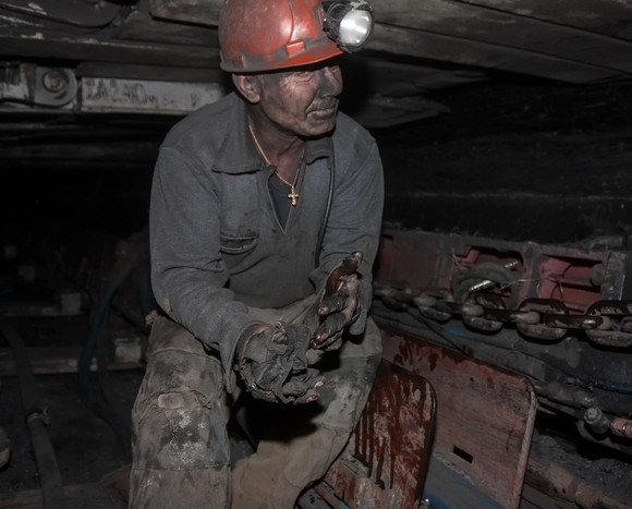 A dirt-covered coal miner in a coal mine