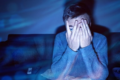 Scared person with hands over face