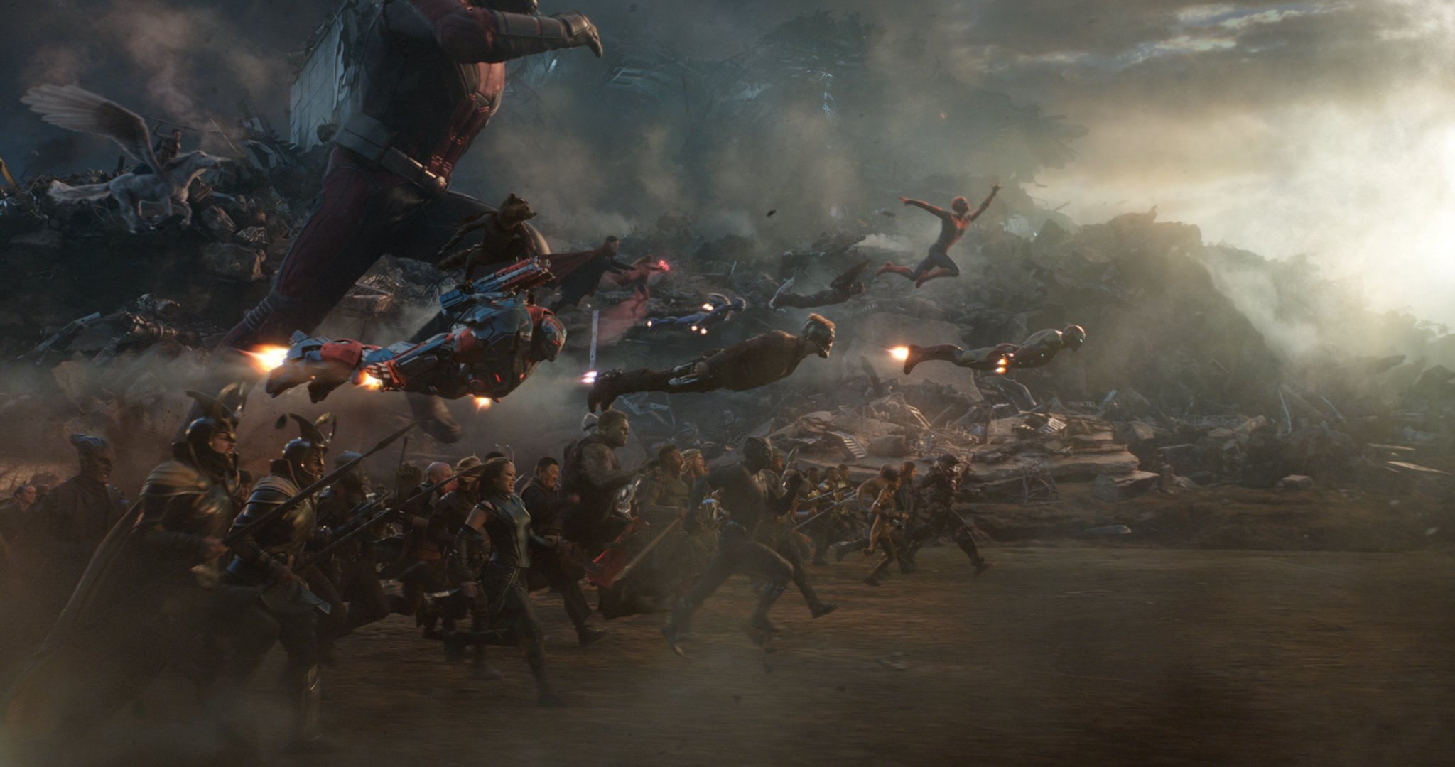 A host of Avengers running and flying into battle against an unseen foe.