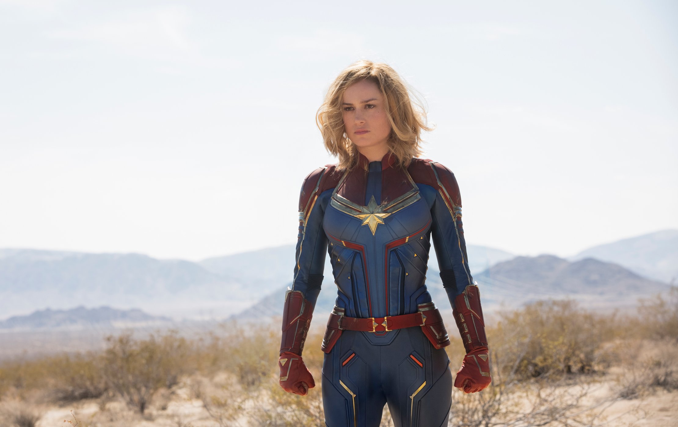 Captain Marvel standing in the dessert.