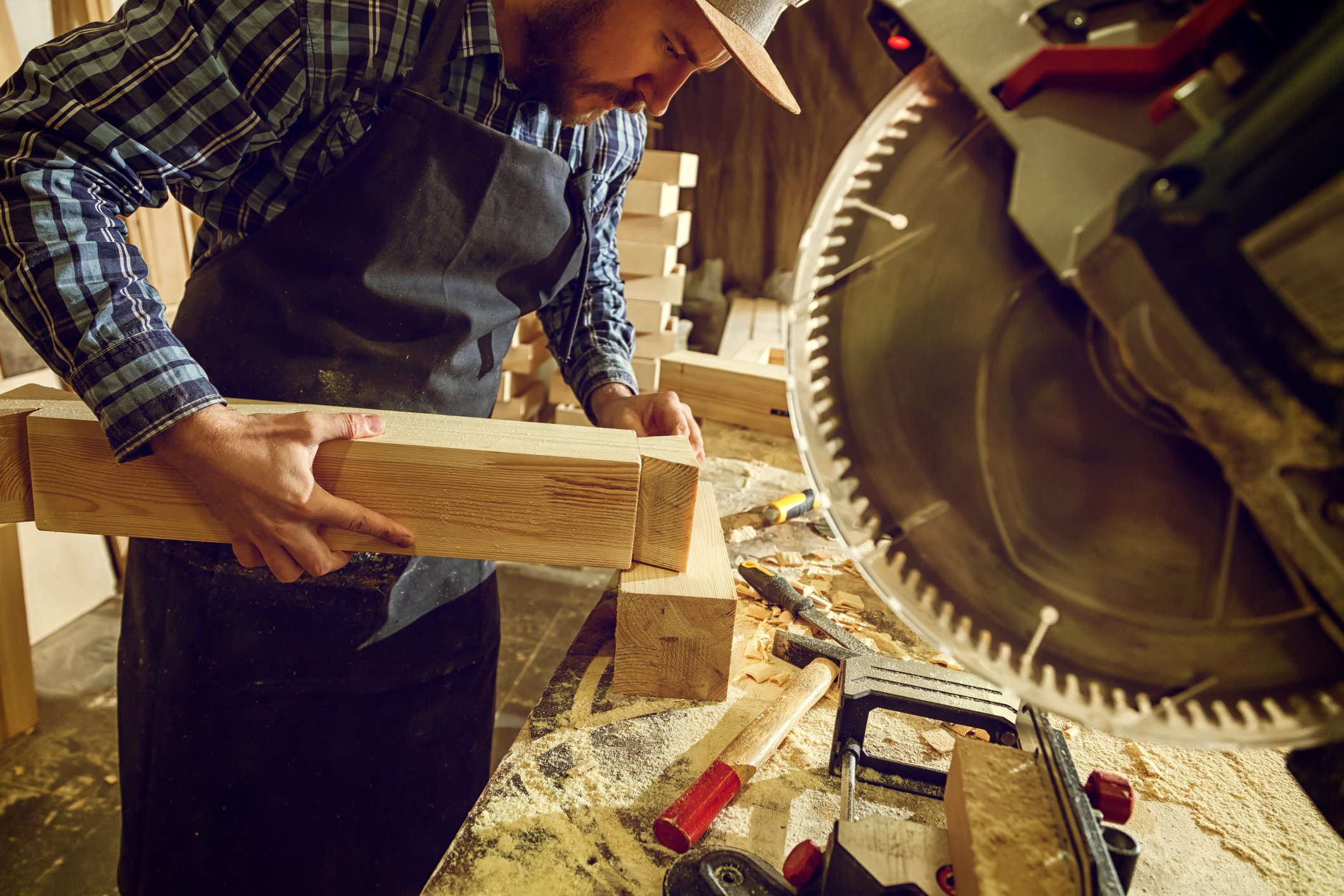 A carpenter prepares to cut wood with a heavy-duty circular saw.