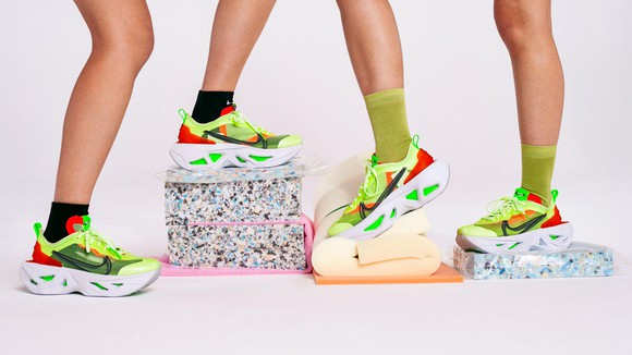 Two pairs of feet standing on a towel and exercise blocks wearing the new Nike ZoomX in bright red and green colors.