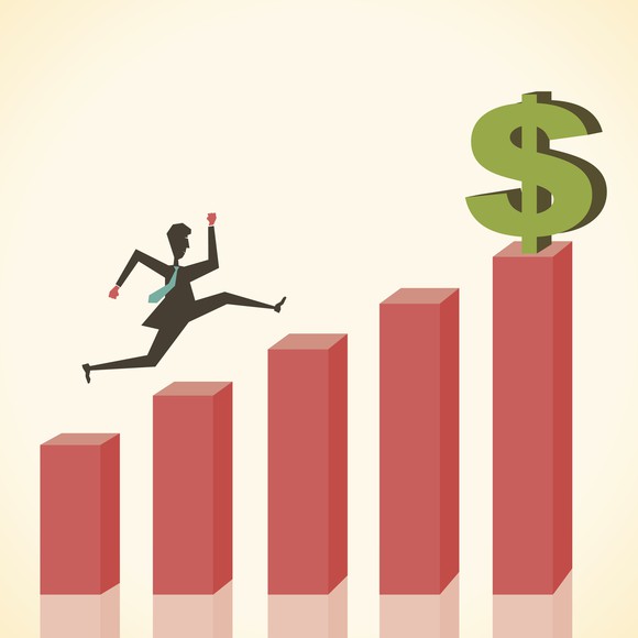 A man leaps up a rising bar chart with a dollar sign on the final bar