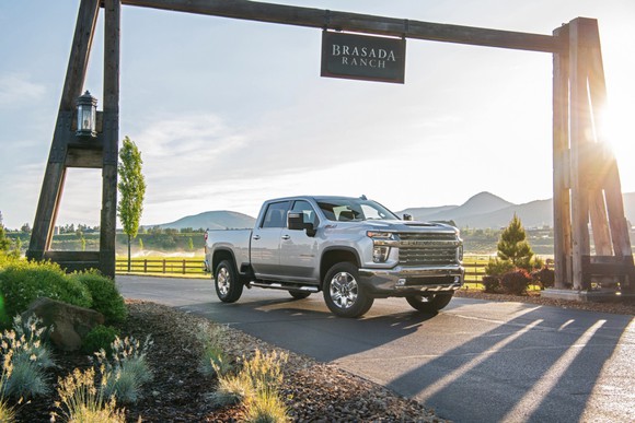 Silverado truck parked in front of a sunset, under a sign that reads "Brasada Ranch."