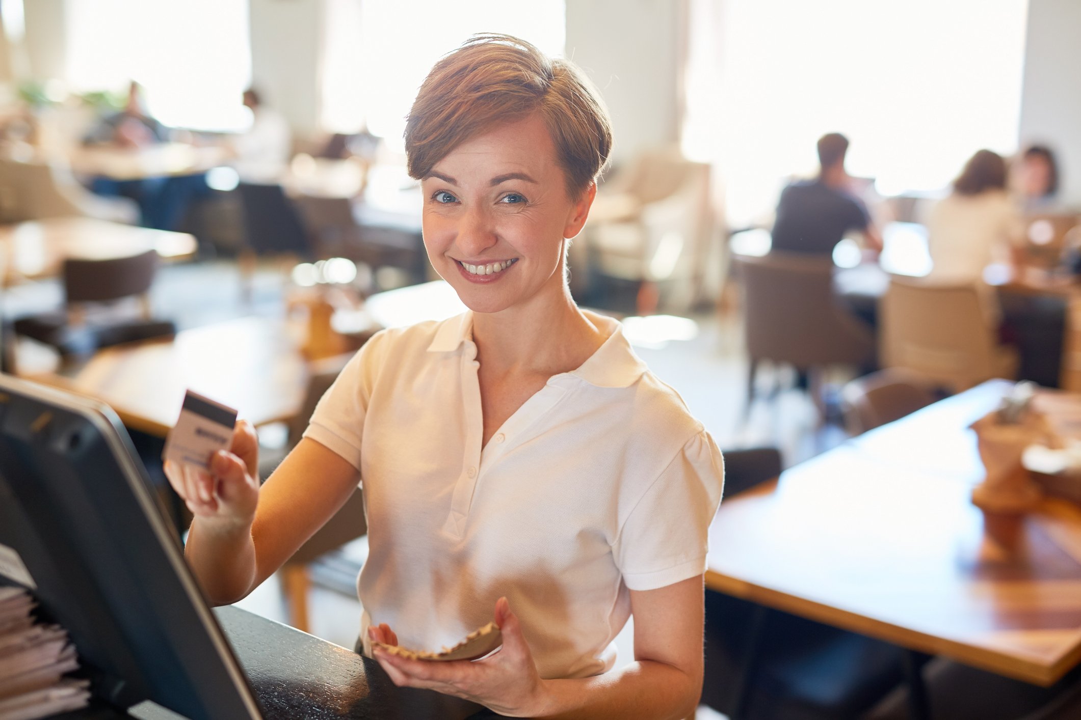 A restaurant owner processes a credit card payment for a meal.