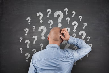 Question marks on chalkboard with man