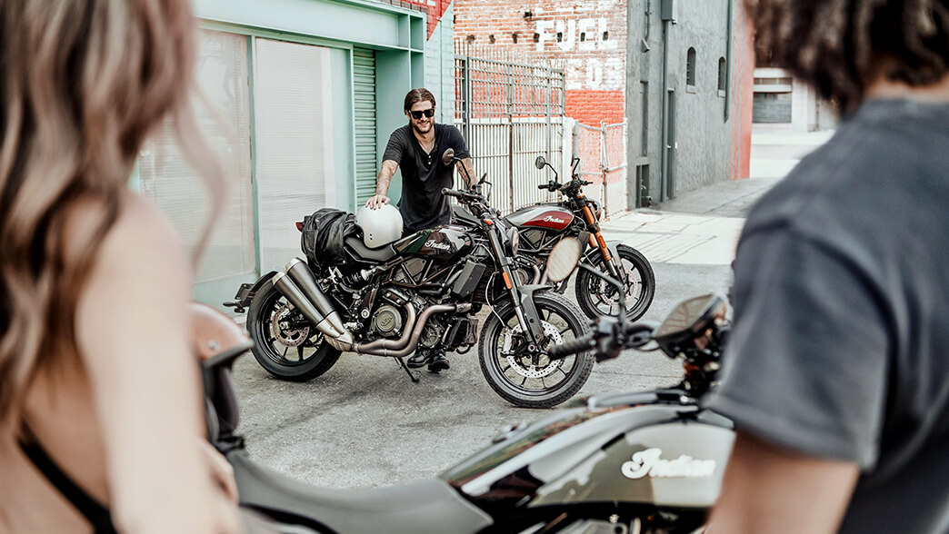Man standing in between two motorcycles