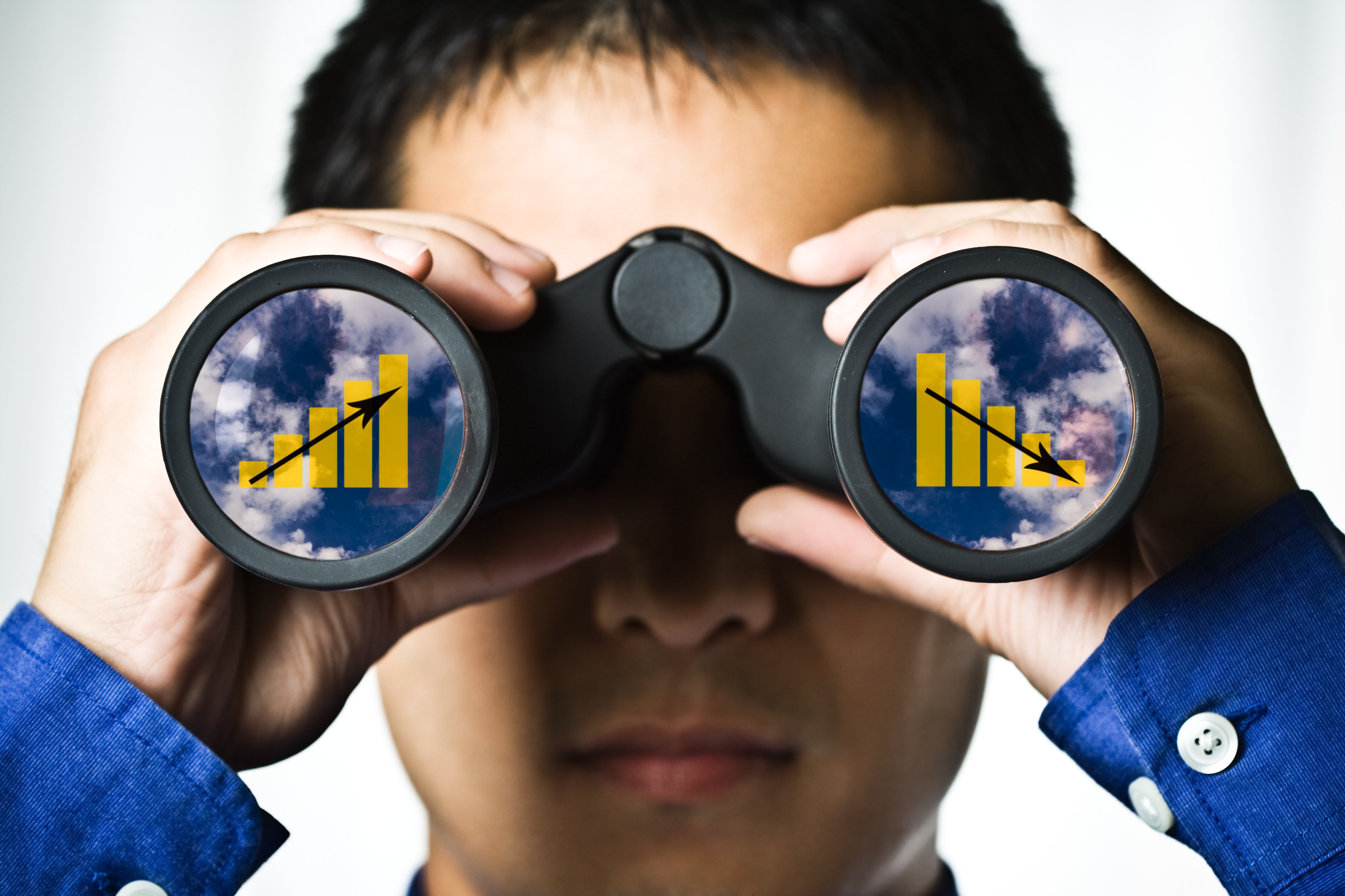 Man holding binoculars with charts in both lenses.