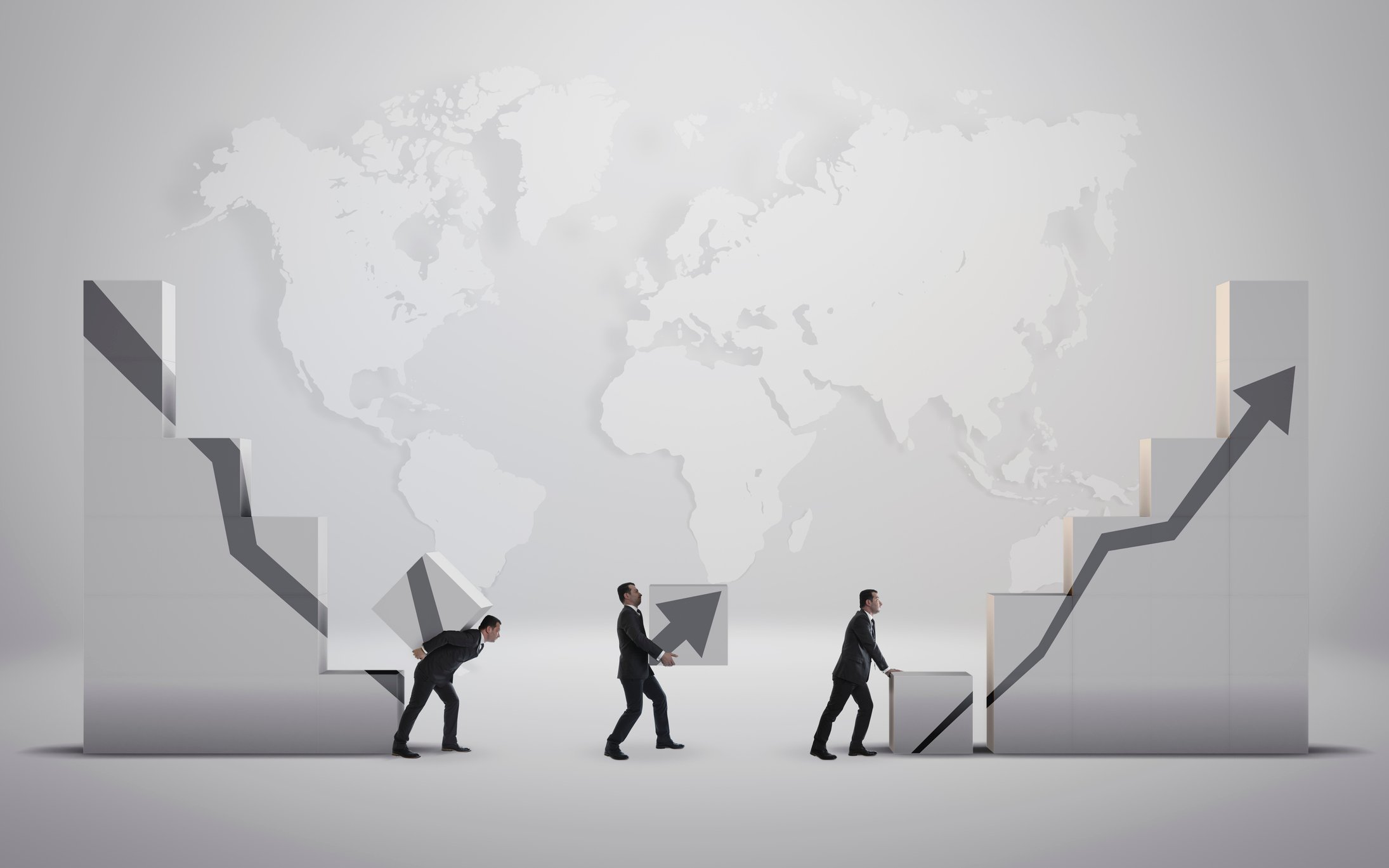 People carrying blocks that create a picture of a falling then rising line chart