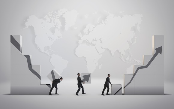 People carrying blocks that create a picture of a falling then rising line chart