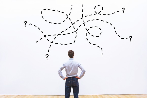 Man with hands on hips looking at complicated diagram on a wall