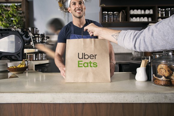 An Uber Eats courier picks up a meal.