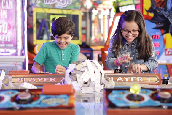 Two children playing arcade game