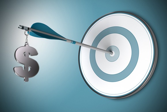 Arrow with dollar sign hanging from end stuck in bull's-eye on target