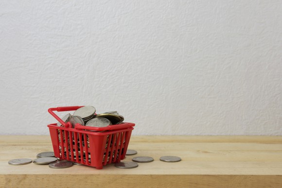 Coins sitting in a grocery basket.