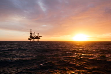 Silhouette of an offshore drilling rig at sunset.