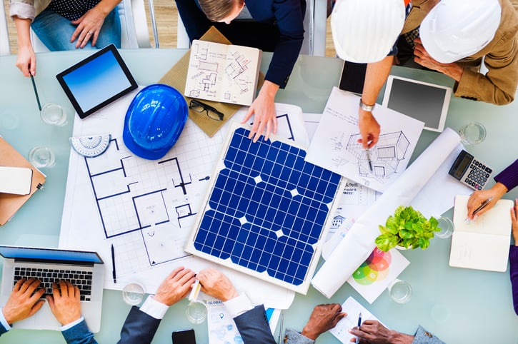 People sitting around a table planning a solar energy project.