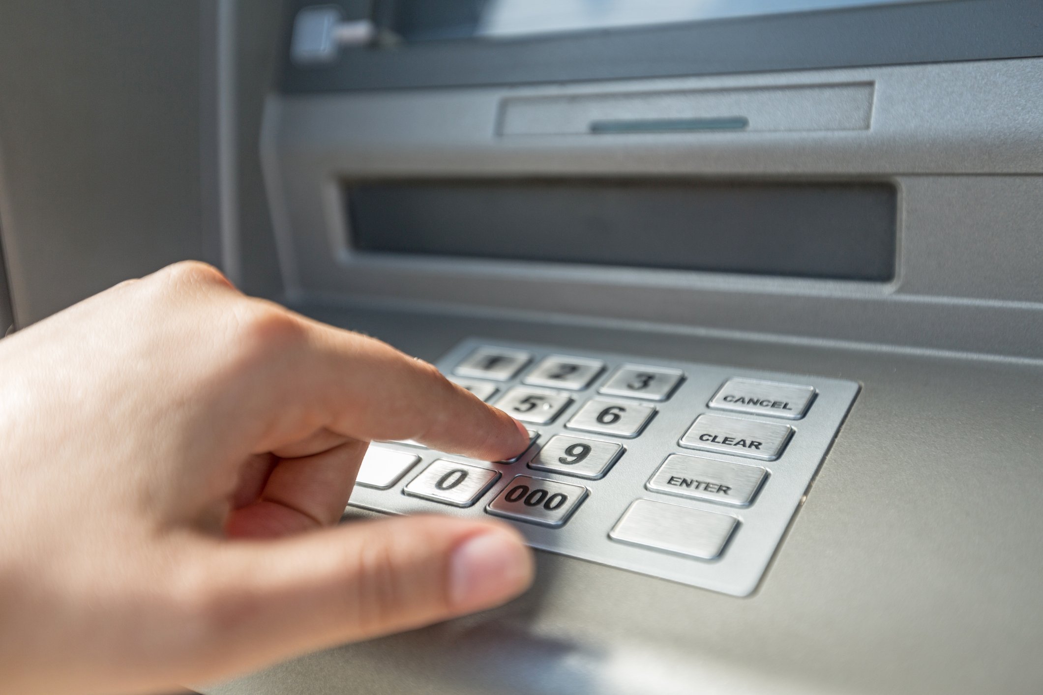 A person uses an ATM.