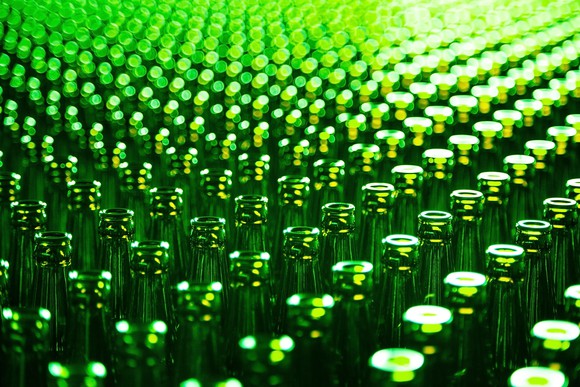 Table full of green glass bottles that have just been manufactured.