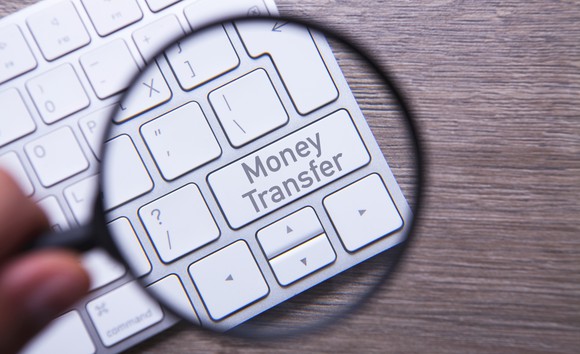 Close-up of a keyboard with the words Money Transfer written on the enter key.