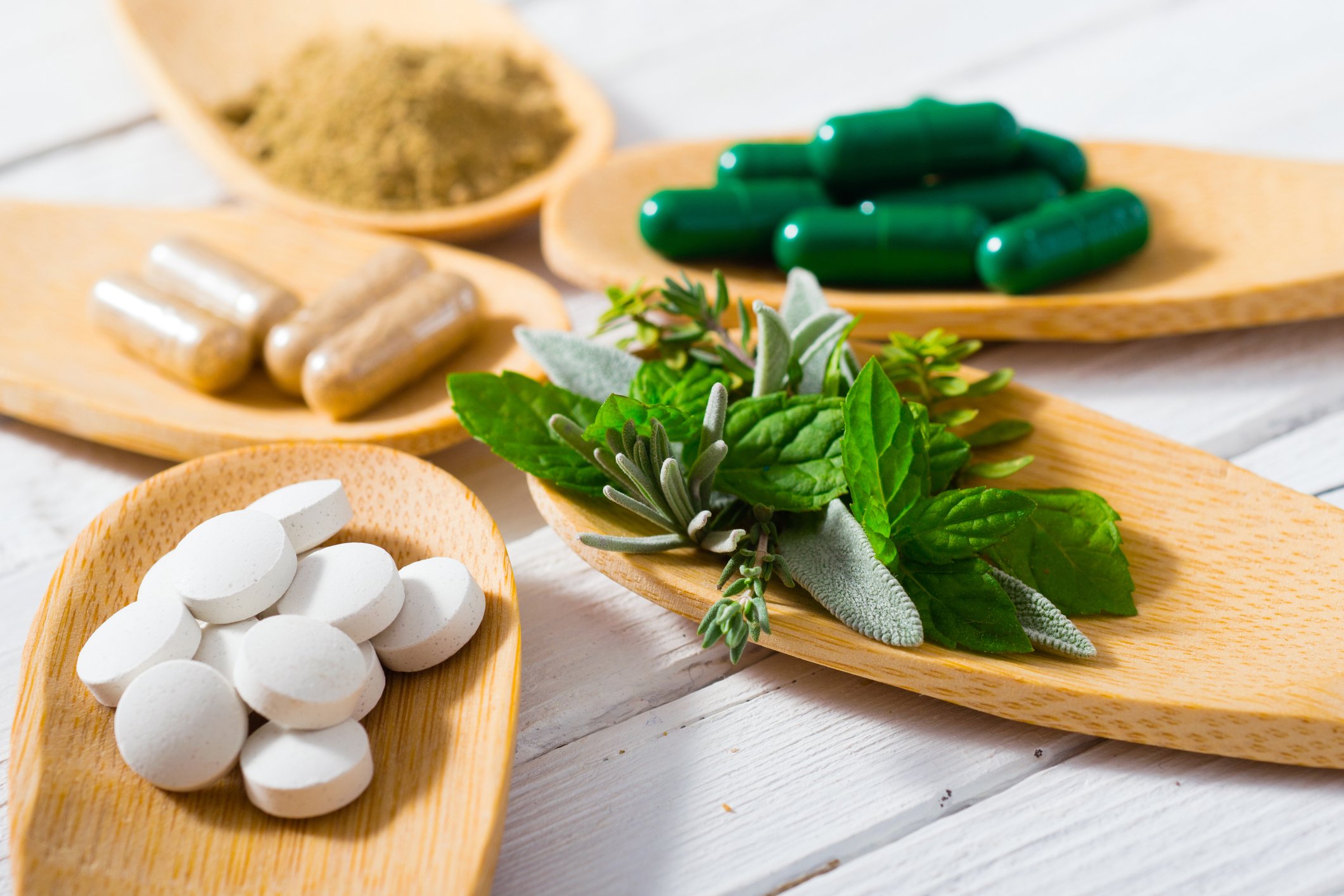 Supplements on wooden spoons on a table. 
