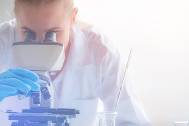 Woman scientist looking through microscope