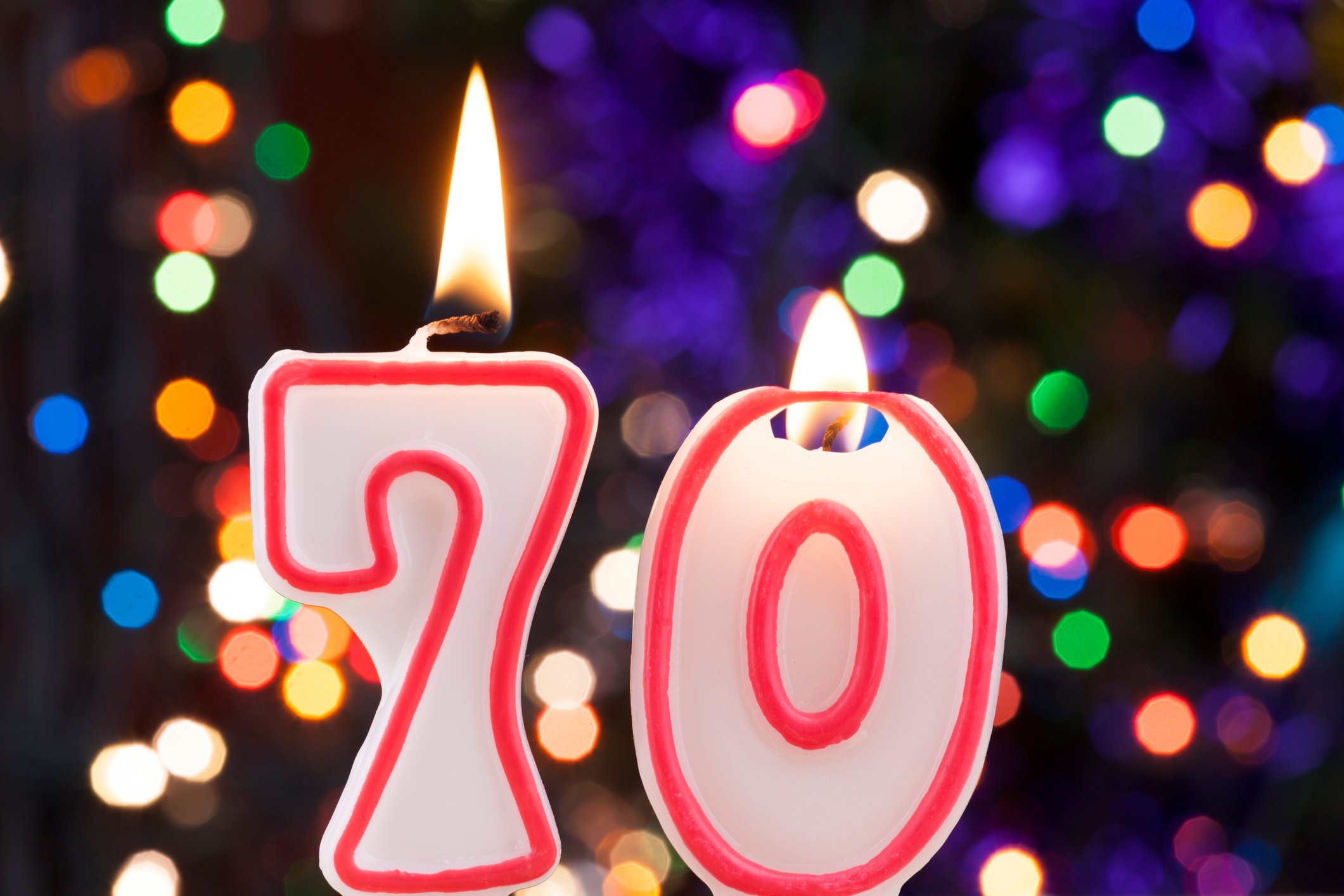 We see two candles on a birthday cake -- spelling the number 70.