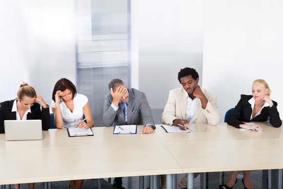 Five businesspeople in a meeting, looking upset