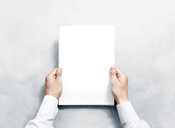 A person holds a blank piece of paper.