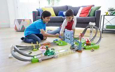 Two boys playing with a racing track