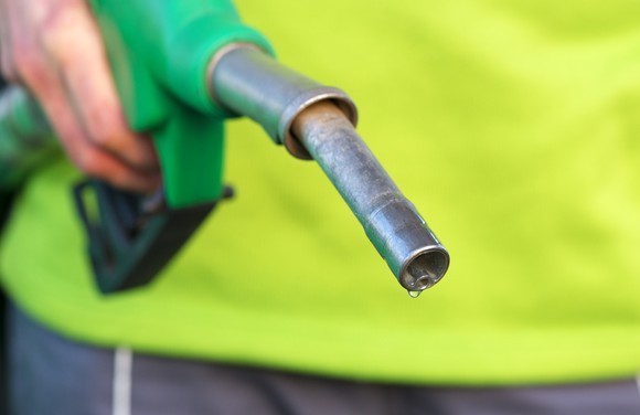 A hand holding a green diesel pump