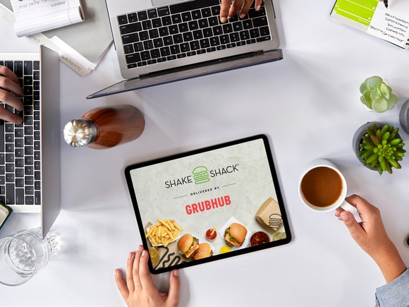 A tablet displaying Shake Shack and Grubhub's logos.