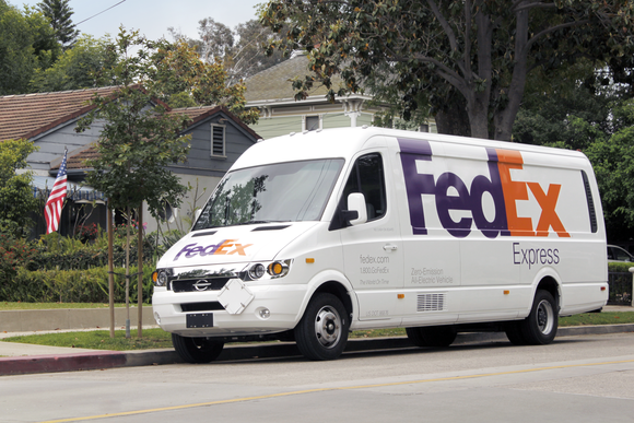 A FedEx delivery van parked on a residential street.