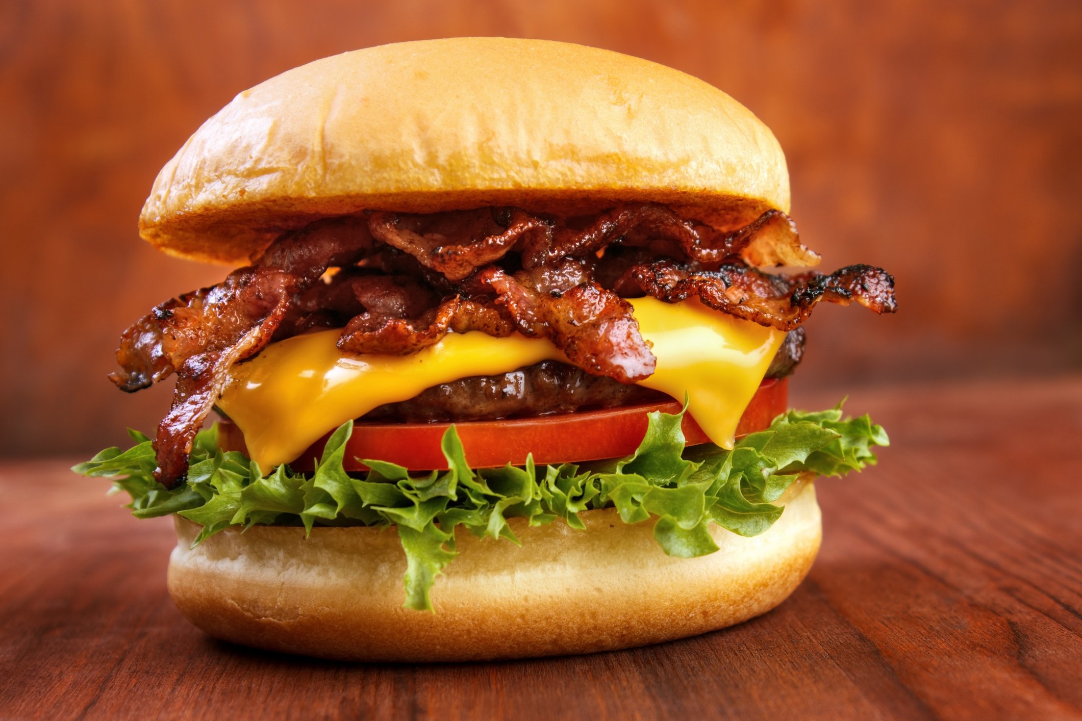 Bacon cheeseburger atop a table.