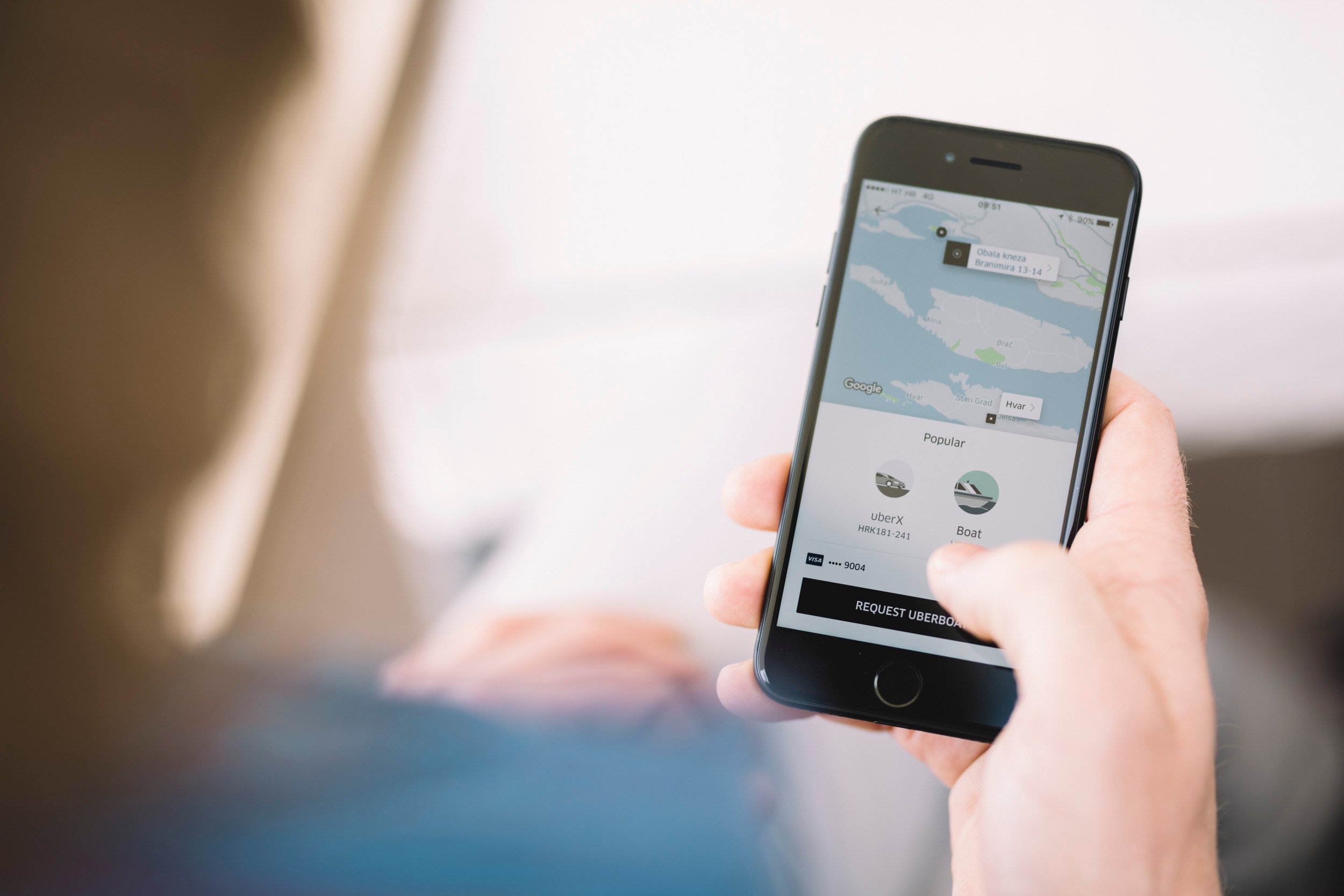 The Uber app running on a smartphone with a user deciding between two fare choices.