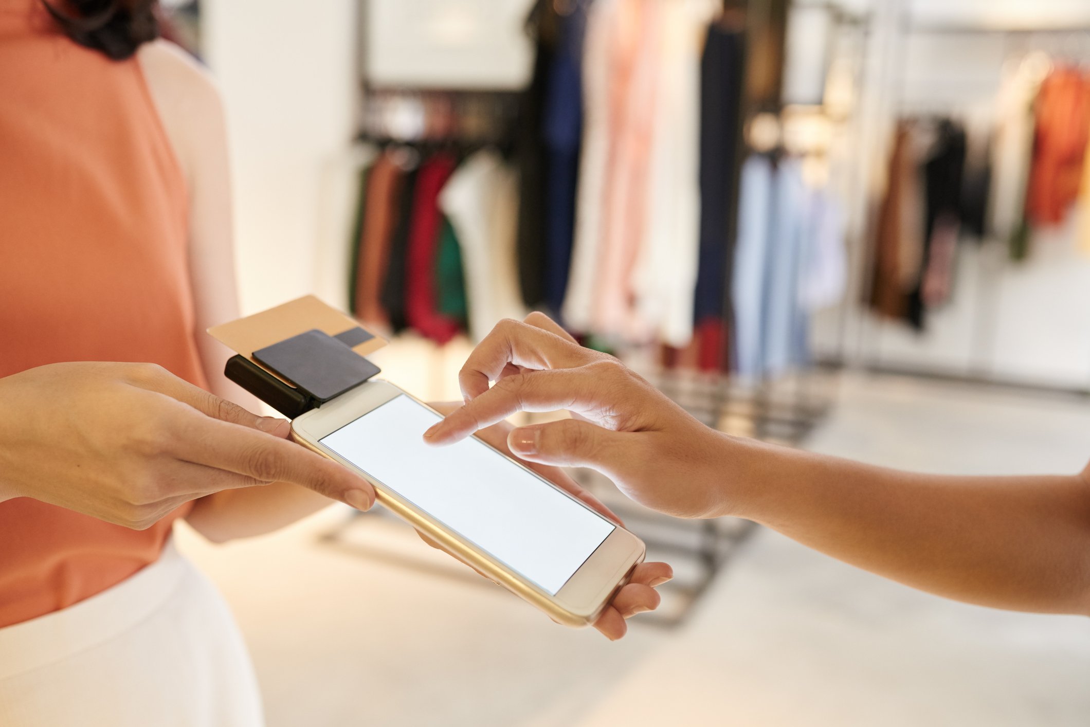 A customer interacts with a tablet display while buying clothes.