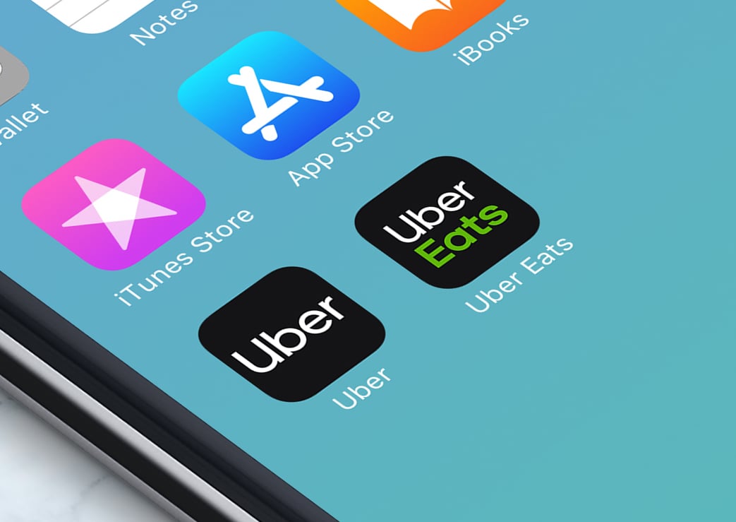 A close up of a smartphone's screen showing the Uber and Uber Eats application icons.