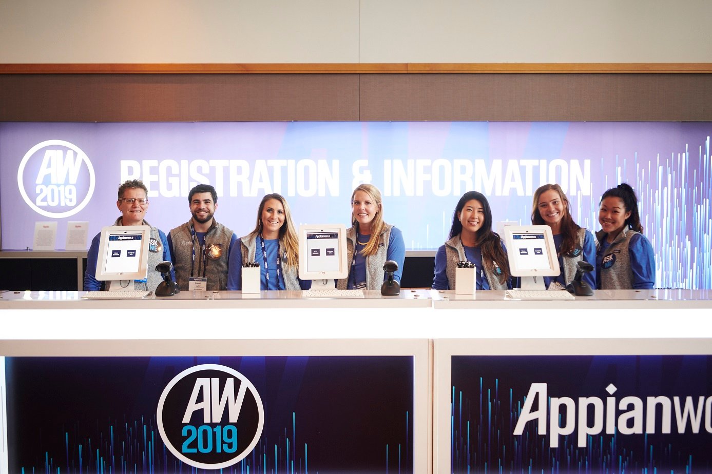 Seven people behind a desk marked Appianworld 2019.