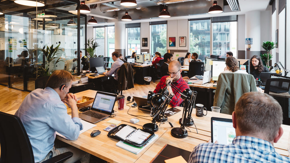 Several people working inside a WeWork workspace