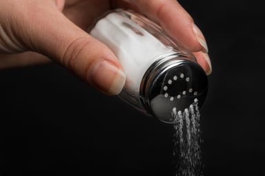 Hand pouring salt from a shaker