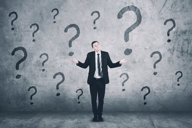 Shrugging businessman with question marks
