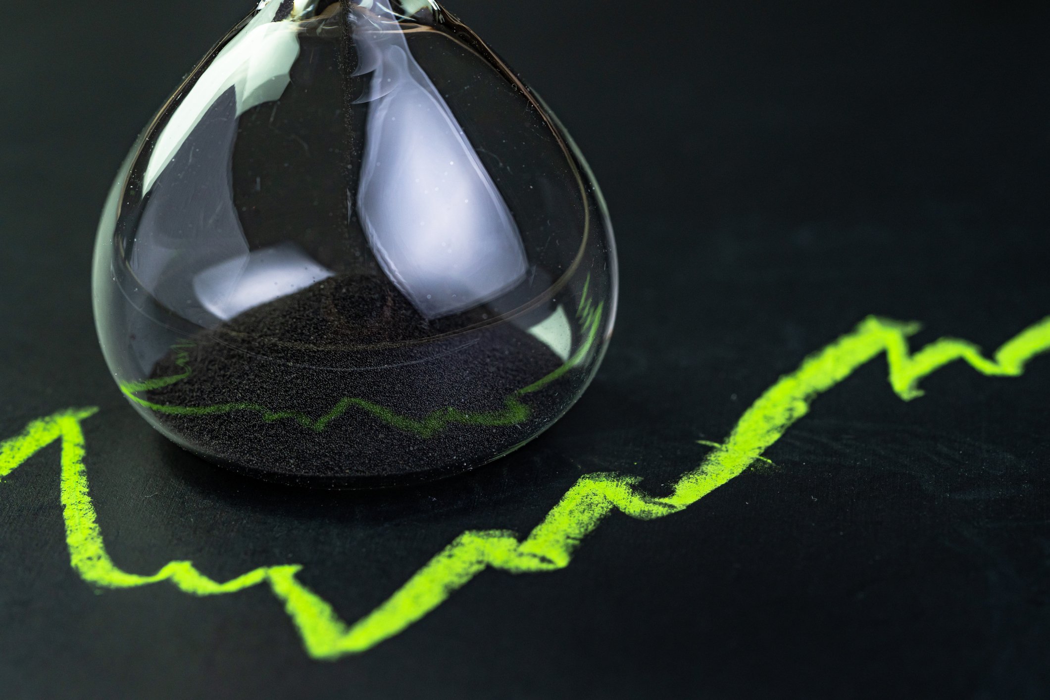 A rising chart reflected in an hourglass.