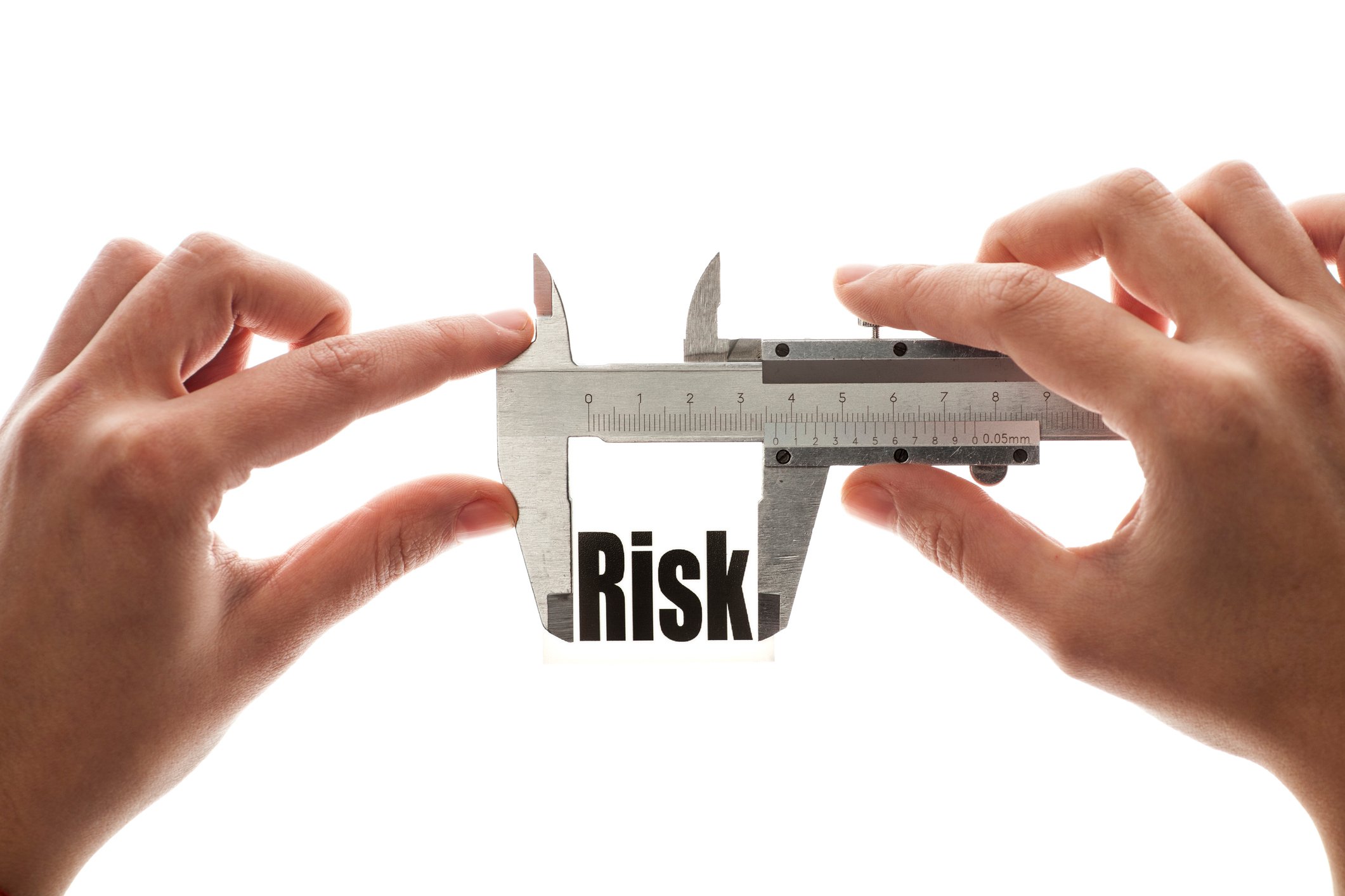 Hands holding caliper on the word risk.