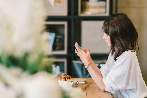 A woman looking at a smartphone at a cafe