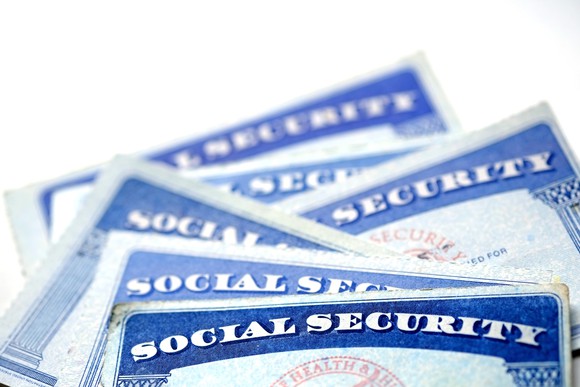 Six Social Security cards piled on top of each other